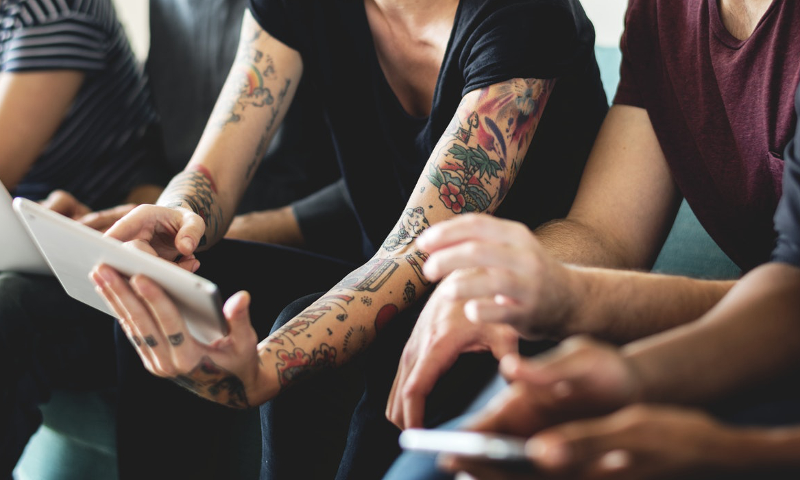 A group gathers around tablet